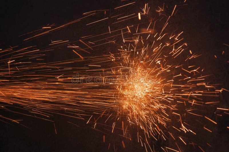 Glowing flow of sparks in the dark. Process of working with metal. Splatter royalty free stock photo