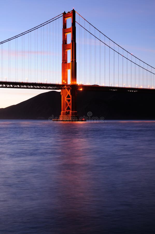 Glowing Golden Gate Bridge tower at sunset