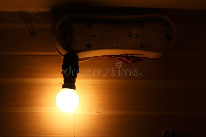 Glowing light bulb in Lamp Socket Hanging on Wire royalty free stock images