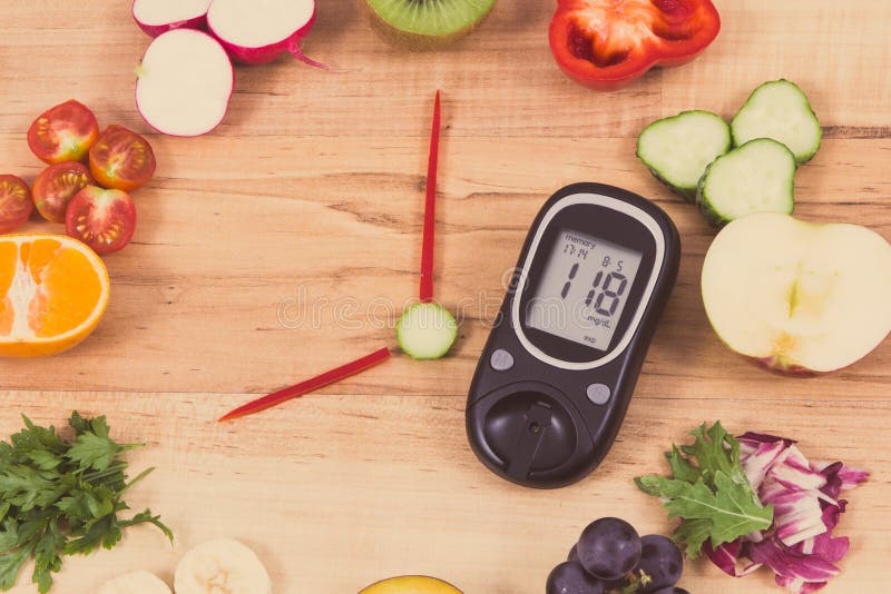 Glucometro con il risultato del livello di zucchero e dell'orologio fatto di frutta con verdure che mostrano il tempo per la cola fotografia stock libera da diritti