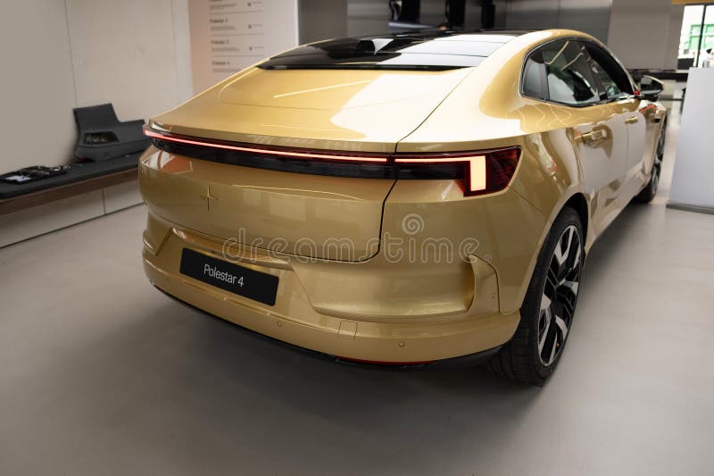 Shiny golden car Polestar 4 upcoming all-electric SUV coupe by Polestar, Volvo subsidiary, long-range, luxurious, and eco-friendly vehicle showcased in showroom. Shiny golden car Polestar 4 upcoming all-electric SUV coupe by Polestar, Volvo subsidiary, long-range, luxurious, and eco-friendly vehicle showcased in showroom