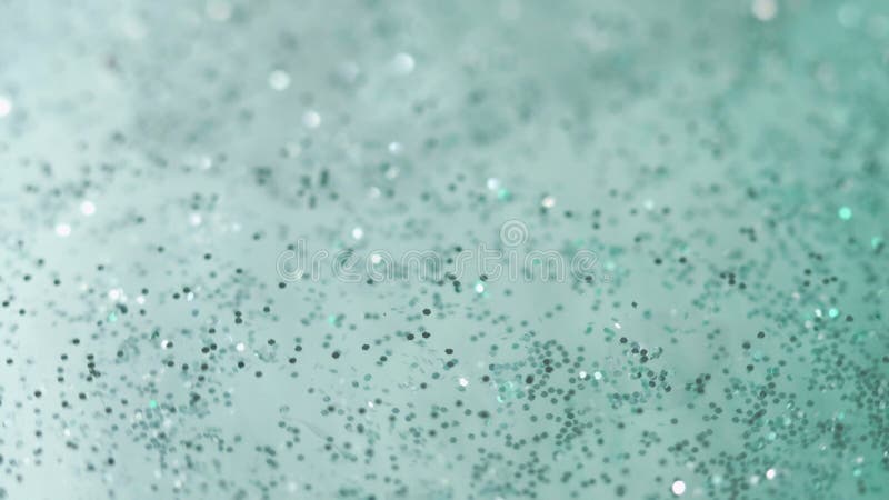 Glitter paint. Celebrate sequins. Defocused blue green blink particles rotate shiny fluid sparkling emulsion bokeh abstract art background. Glitter paint. Celebrate sequins. Defocused blue green blink particles rotate shiny fluid sparkling emulsion bokeh abstract art background.