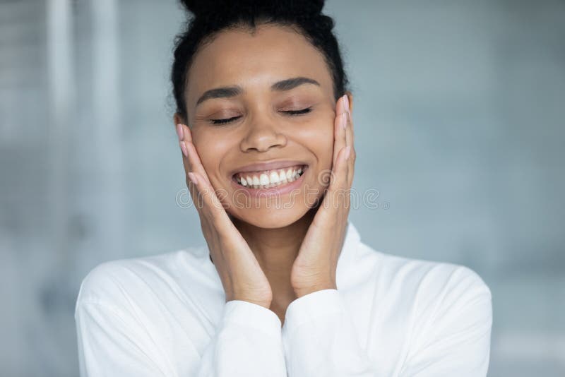 Glücklich entspannt tausendjährige afrikanische Mädchen im Bademantel genießen home spa stockfoto
