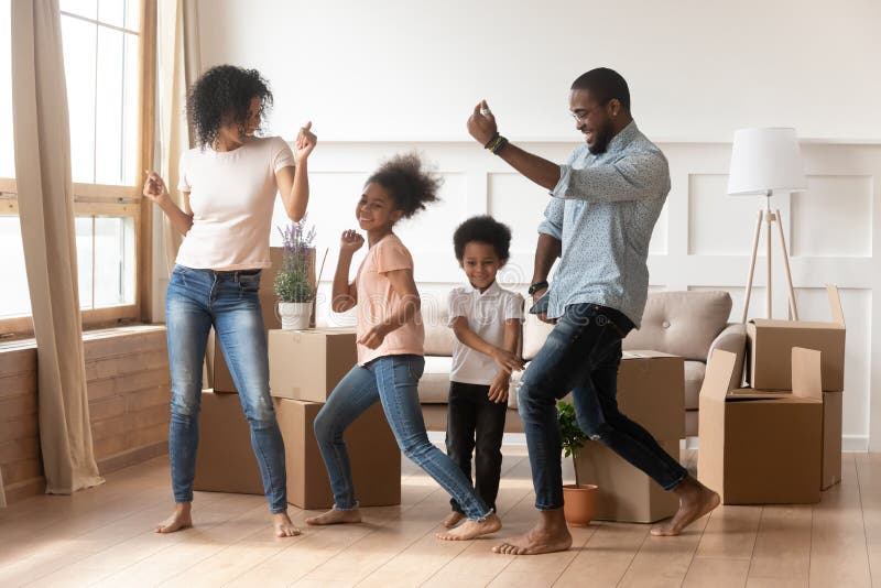 Glückliche Afroamerikanereltern und -kinder, die beweglichen Tag feiernd tanzen stockfotografie