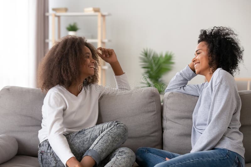 Glückliche Afroamerikanermutter und jugendlich Tochter, die zu Hause plaudert stockbilder Glückliche Afroamerikanermutter und jugendlich Tochter, die zu Hause plaudert stockbilder