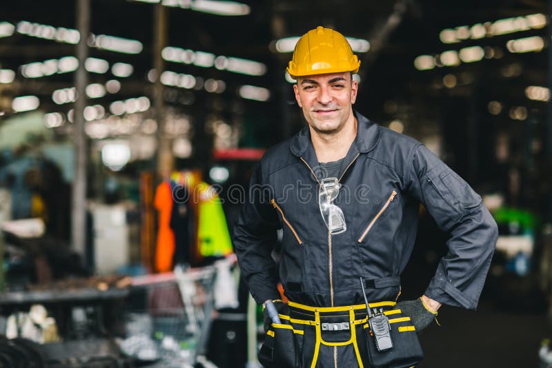 Glückliche Arbeitnehmer, schöne Arbeit des Porträtlächelns mit Sicherheitsklagenwerkzeugen Gürtel und Funkdienstmann in der Fabri lizenzfreie stockfotos