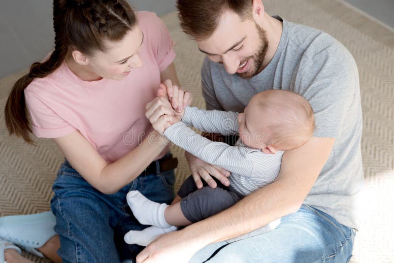 Glückliche Eltern, die mit Baby spielen lizenzfreie stockfotos Glückliche Eltern, die mit Baby spielen lizenzfreie stockfotos