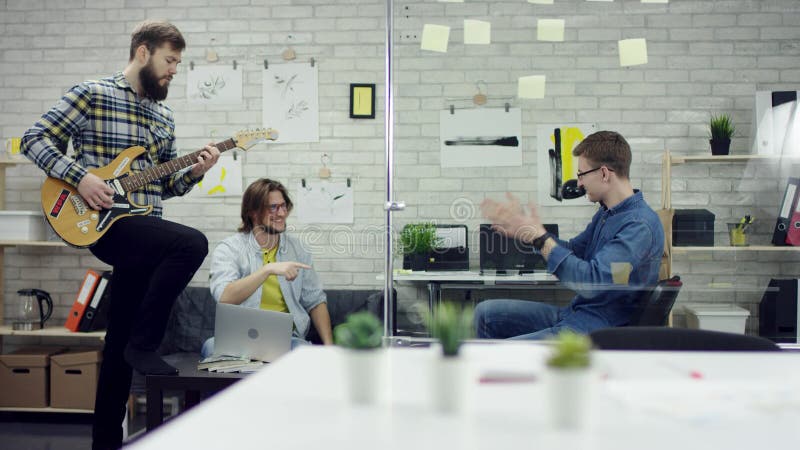 Glückliche erfolgreiche Geschäftsleute im Büro, das werfende Dokumente des Spaßes hat Eine Arbeitskraft spielt das guiter Sie sin