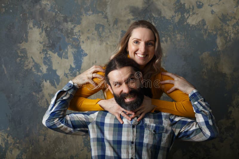 Glückliche erwachsene Paare, die das Lächeln breit und das Betrachten der Kamera umarmen stockfoto