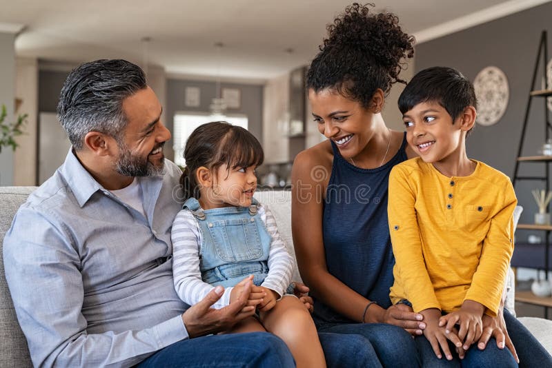 Glückliche ethnische Familie mit zwei Kinder Couch