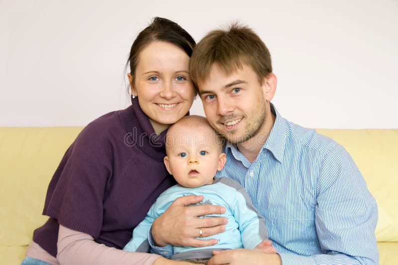 Portrait of happy family sitting on sofa at home. Portrait of happy family sitting on sofa at home