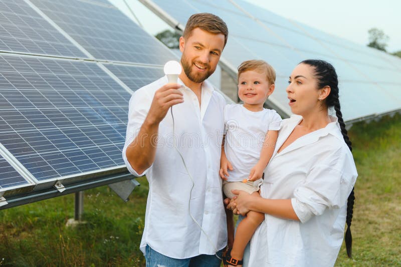 Glückliche Familie bei Solarmodulen. alternative Energiequelle stockbilder