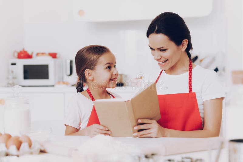 Glückliche Familie in der Küche backen und lasen Buch lizenzfreie stockbilder Glückliche Familie in der Küche backen und lasen Buch lizenzfreie stockbilder