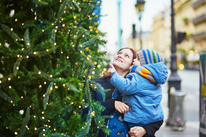 Glückliche Familie des schauenden zwei Weihnachtsbaums stockbild Glückliche Familie des schauenden zwei Weihnachtsbaums stockbild