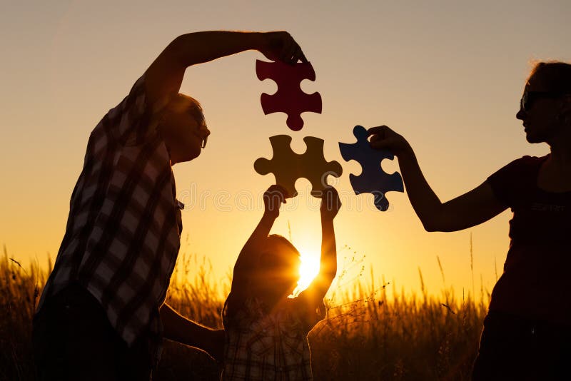 Glückliche Familie, die am Park zur Sonnenuntergangzeit spielt lizenzfreie stockfotos Glückliche Familie, die am Park zur Sonnenuntergangzeit spielt lizenzfreie stockfotos