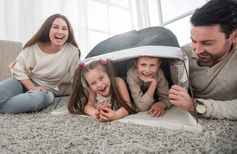 Glückliche Familie, die Spaß in einer neuen Wohnung hat lizenzfreie stockfotos Glückliche Familie, die Spaß in einer neuen Wohnung hat lizenzfreie stockfotos