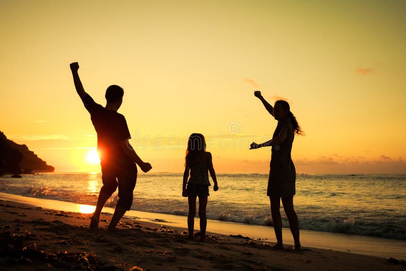 Glückliche Familie, die am Strand spielt lizenzfreie stockbilder Glückliche Familie, die am Strand spielt lizenzfreie stockbilder