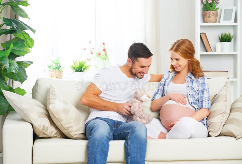 Glückliche Familie in Erwartung der Geburt des Babys Schwangeres woma lizenzfreies stockbild Glückliche Familie in Erwartung der Geburt des Babys Schwangeres woma lizenzfreies stockbild