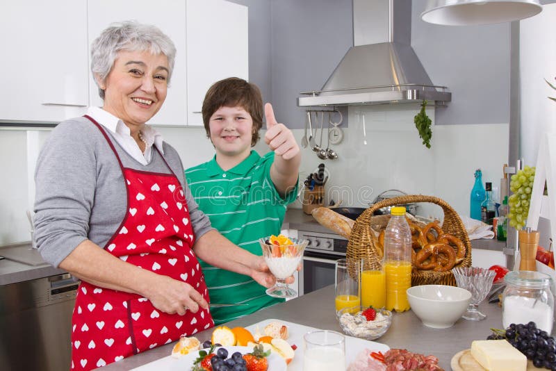 Glückliche Familie: Großmutter und Enkel, die zusammen kochen lizenzfreies stockfoto Glückliche Familie: Großmutter und Enkel, die zusammen kochen lizenzfreies stockfoto
