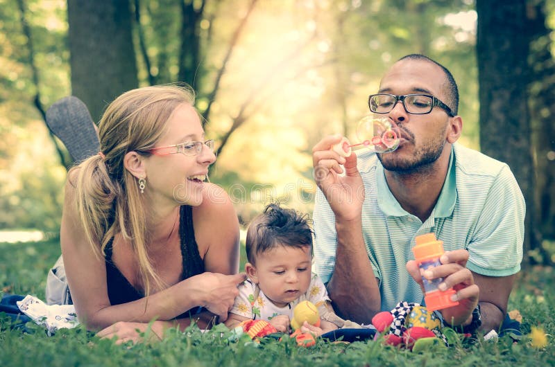 Glückliche Familie im Park im Retro- Filtereffekt oder in instagram FI lizenzfreie stockfotografie Glückliche Familie im Park im Retro- Filtereffekt oder in instagram FI lizenzfreie stockfotografie
