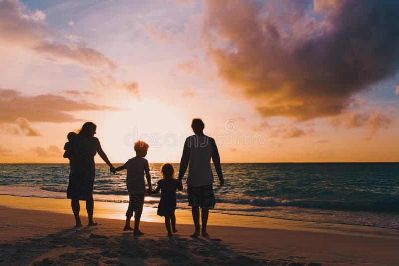 Glückliche Familie mit Baumkindern gehen am Sonnenuntergangstrand lizenzfreie stockfotos Glückliche Familie mit Baumkindern gehen am Sonnenuntergangstrand lizenzfreie stockfotos