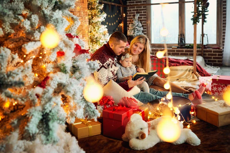 Glückliche Familie mit einem Baby in einem Weihnachtsraum stockfotos Glückliche Familie mit einem Baby in einem Weihnachtsraum stockfotos