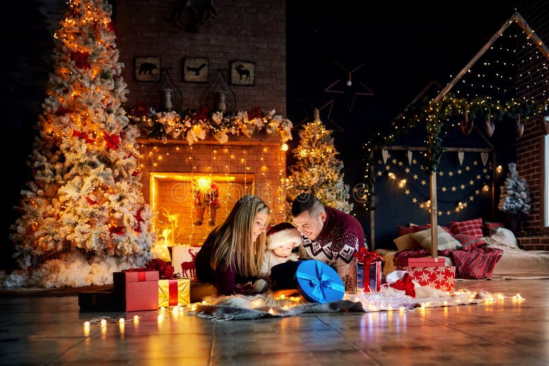Glückliche Familie mit einem Baby in einem Weihnachtsraum lizenzfreies stockbild Glückliche Familie mit einem Baby in einem Weihnachtsraum lizenzfreies stockbild