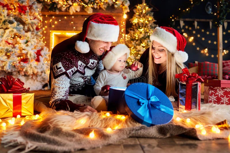 Glückliche Familie mit einem Baby in einem Weihnachtsraum stockfoto Glückliche Familie mit einem Baby in einem Weihnachtsraum stockfoto