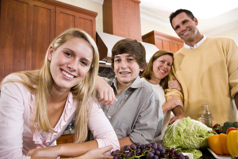 Glückliche Familie mit Jugendkindern in der Küche lizenzfreie stockfotos Glückliche Familie mit Jugendkindern in der Küche lizenzfreie stockfotos