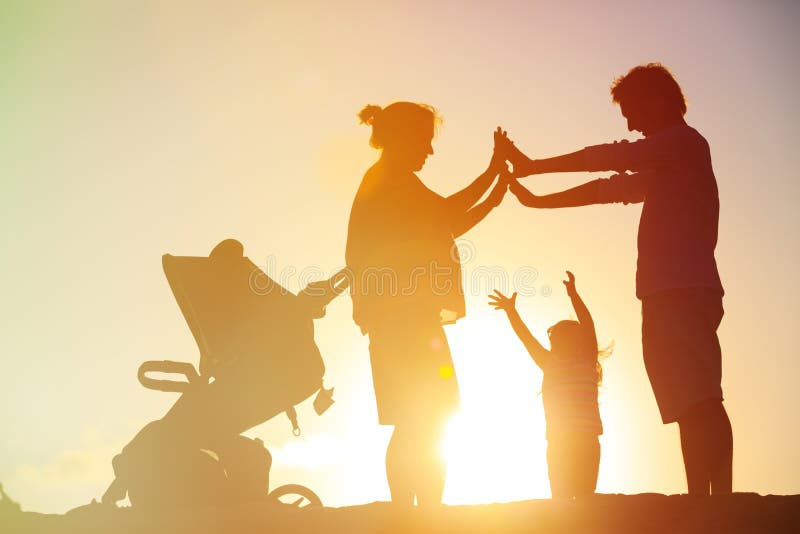 Glückliche Familie mit Kind und schwangerer Mutter zusammen bei Sonnenuntergang stockbilder Glückliche Familie mit Kind und schwangerer Mutter zusammen bei Sonnenuntergang stockbilder