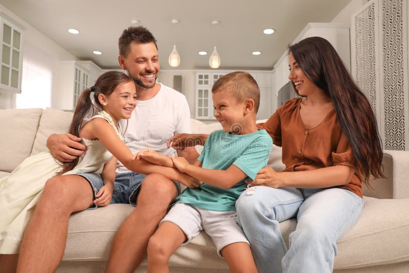 Glückliche Familie mit Kindern, die sich auf dem Sofa amüsieren stockbild