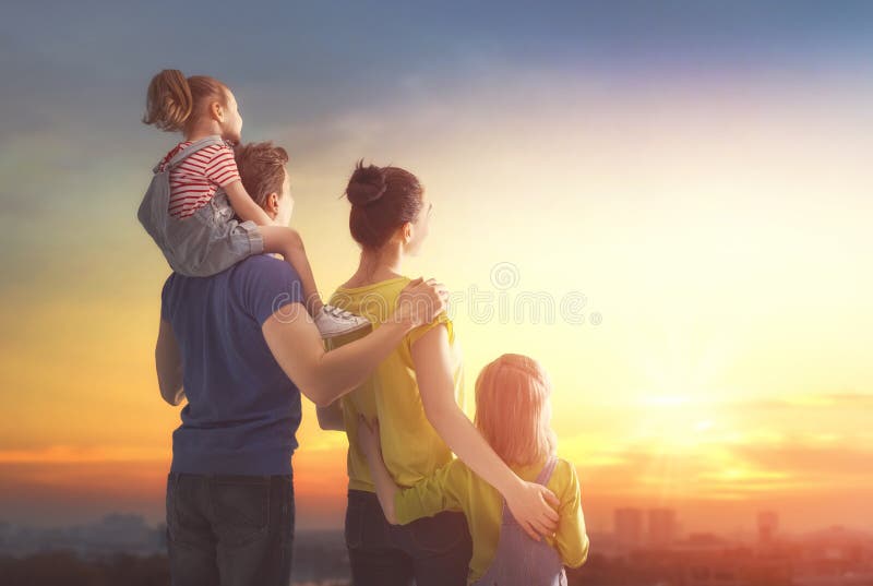Glückliche Familie am Sonnenuntergang stockbild Glückliche Familie am Sonnenuntergang stockbild