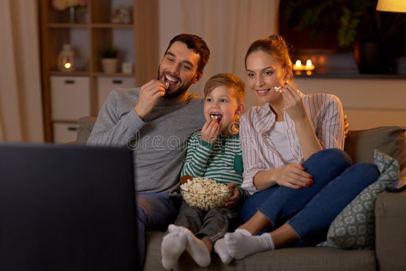 Glückliche Familie zu Hause fernsehend Popcorn. stockbild