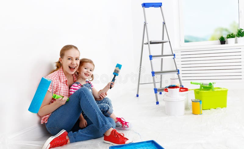 Glückliche Familienmutter und die Kindertochter, die Reparaturen durchführt, malen wal lizenzfreie stockbilder Glückliche Familienmutter und die Kindertochter, die Reparaturen durchführt, malen wal lizenzfreie stockbilder