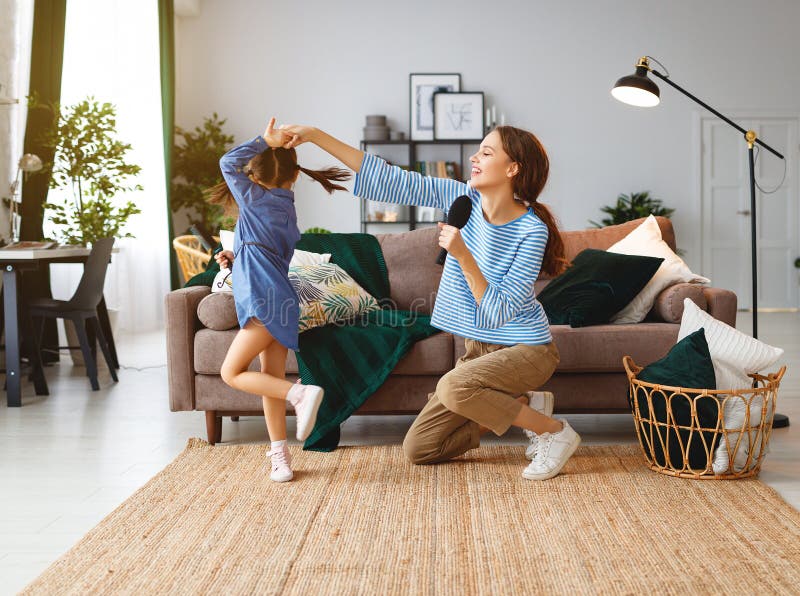 Glückliche Familienmutter und -Kinderspiel zu Hause und mit Kämmen singen lizenzfreie stockfotos