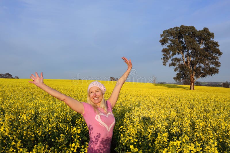 Glückliche Frau auf dem Gebiet des goldenen Canola stockfoto Glückliche Frau auf dem Gebiet des goldenen Canola stockfoto