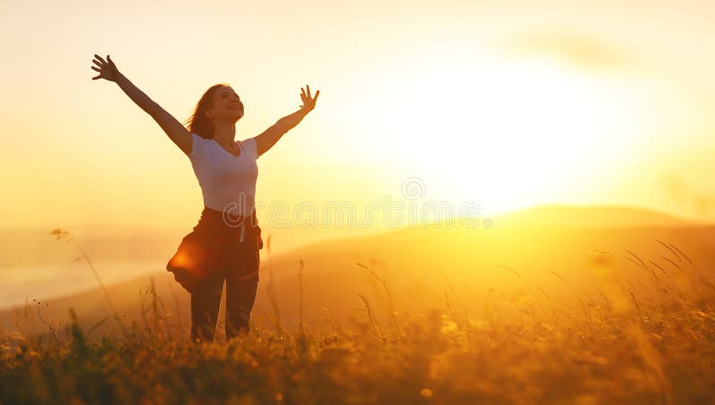 Glückliche Frau auf Sonnenuntergang in Natur iwith offenen Händen