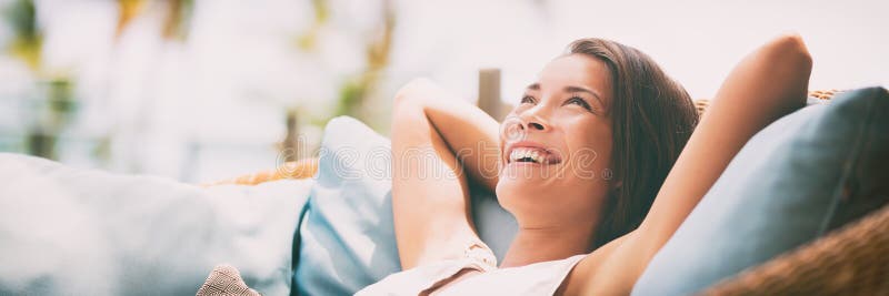 Relaxing home lifestyle happy woman in relax luxury hotel room sofa lying back with arms behind head smiling. Asian girl in comfortable lounging chair travel living. Relaxing home lifestyle happy woman in relax luxury hotel room sofa lying back with arms behind head smiling. Asian girl in comfortable lounging chair travel living