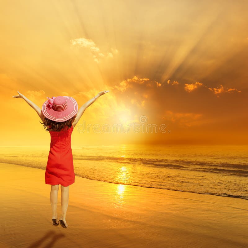 Glückliche Frau, die auf Strand-Sonnenuntergang springt