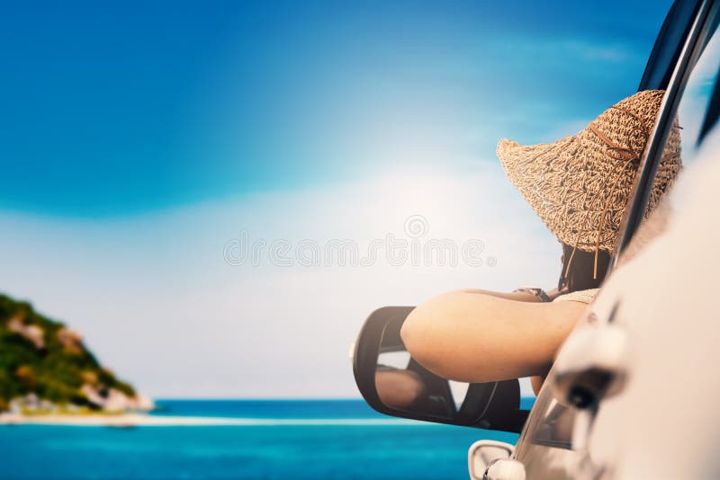 Glückliche Frau, die im Auto und in der reisenden Sommersaison auf dem Meer sitzt