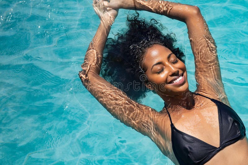 Glückliche Frau, die im Swimmingpool sich entspannt stockfoto Glückliche Frau, die im Swimmingpool sich entspannt stockfoto