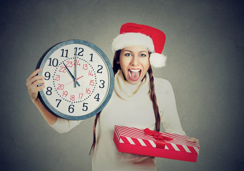 Glückliche Frau, die roten Weihnachtsmann-Hut hält Uhrgeschenkbox trägt stockbilder Glückliche Frau, die roten Weihnachtsmann-Hut hält Uhrgeschenkbox trägt stockbilder