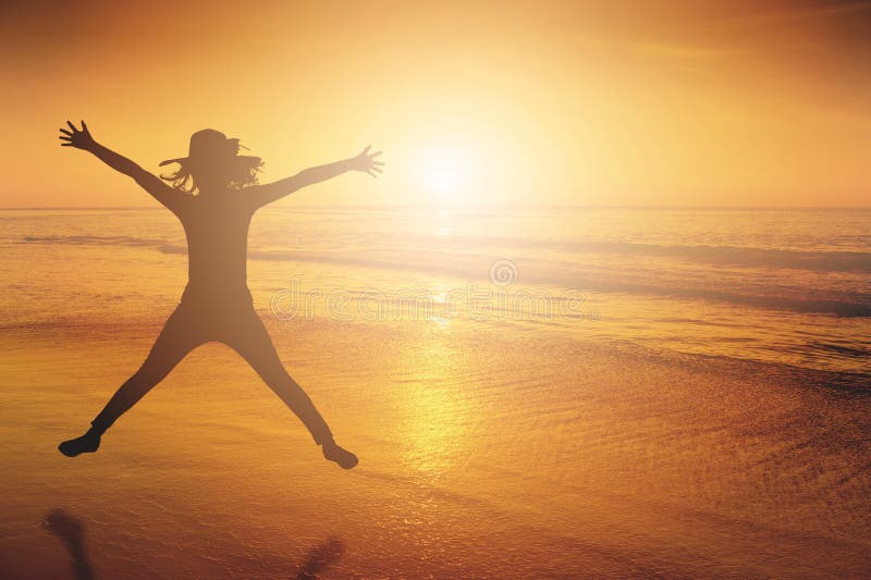 Glückliche Frau, die in Seestrand Sonnenuntergangschattenbild springt Kopieren Sie Platz