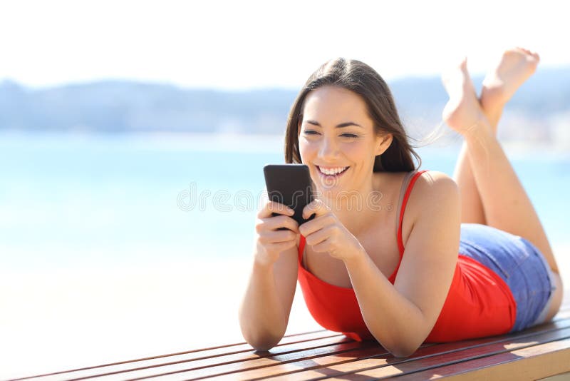 Glückliche Frau, die am Telefon auf dem Strand plaudert lizenzfreie stockfotos Glückliche Frau, die am Telefon auf dem Strand plaudert lizenzfreie stockfotos