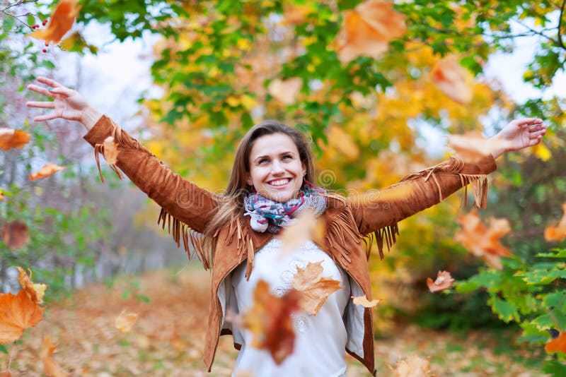 Glückliche Frau wirft Herbstlaub stockbilder Glückliche Frau wirft Herbstlaub stockbilder