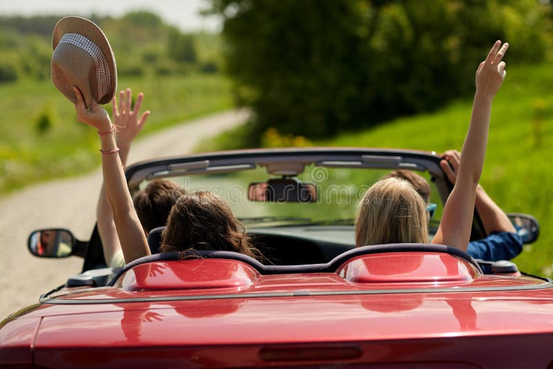 Glückliche Freunde, die in Cabrioletauto am Land fahren lizenzfreies stockfoto