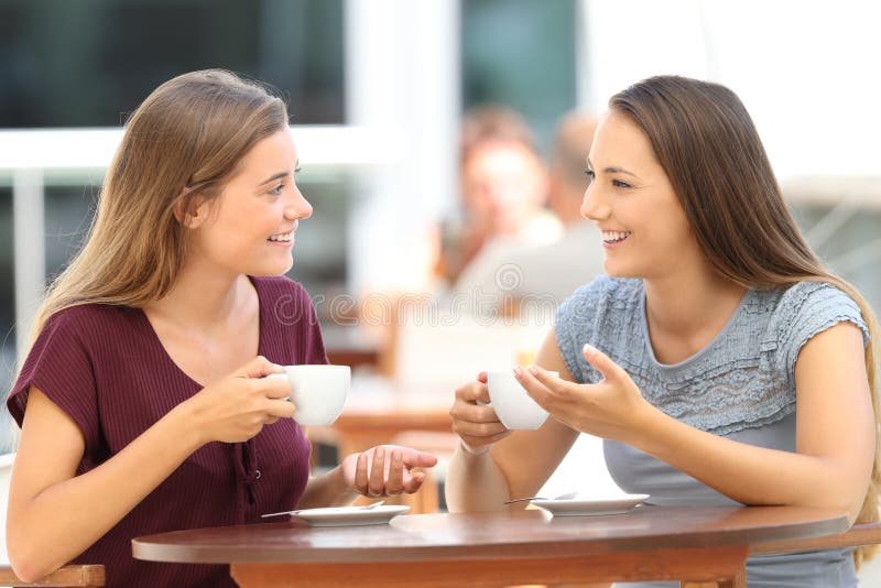 Glückliche Freunde, die ein Gespräch in einer Stange haben lizenzfreie stockfotografie