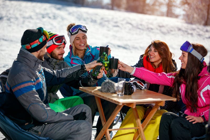 Glückliche Freunde, die mit Getränk nach Ski fahrendem Tag im Café in SK zujubeln stockbilder Glückliche Freunde, die mit Getränk nach Ski fahrendem Tag im Café in SK zujubeln stockbilder