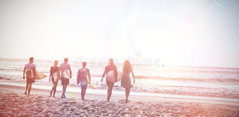 Glückliche Freunde, die mit Surfbrettern gehen stockbilder Glückliche Freunde, die mit Surfbrettern gehen stockbilder