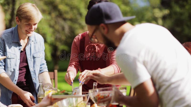 Glückliche Freunde, die am Sommergartenfest zu Abend essen